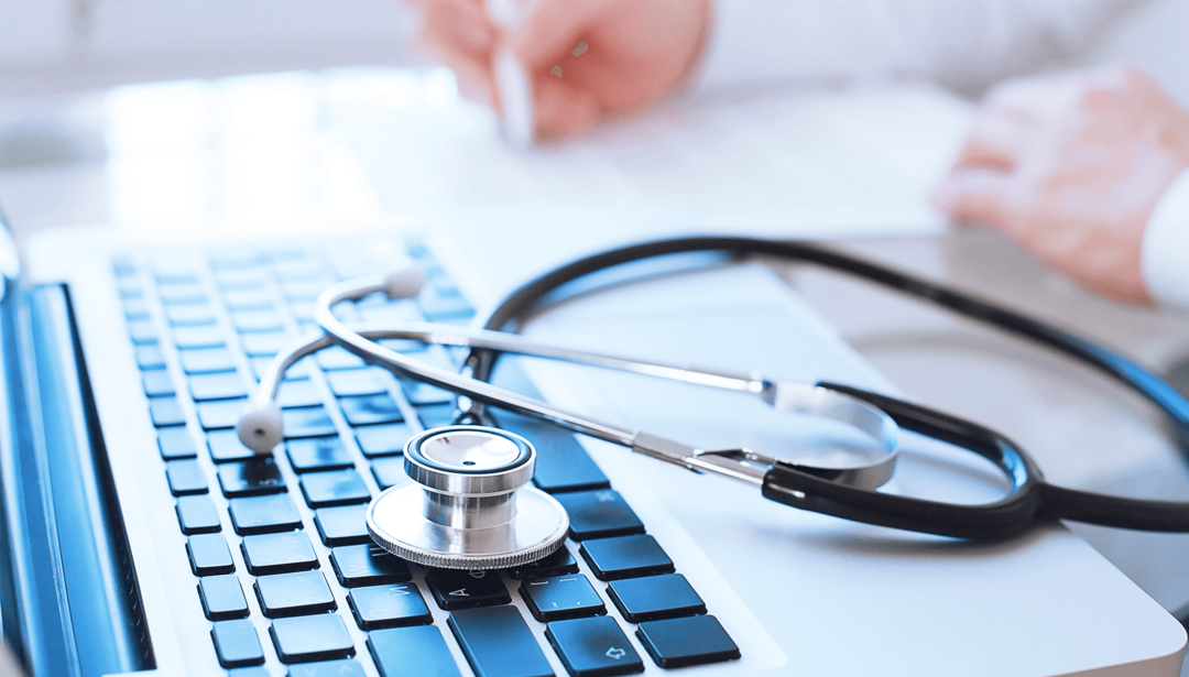 stethoscope laying on computer keyboard