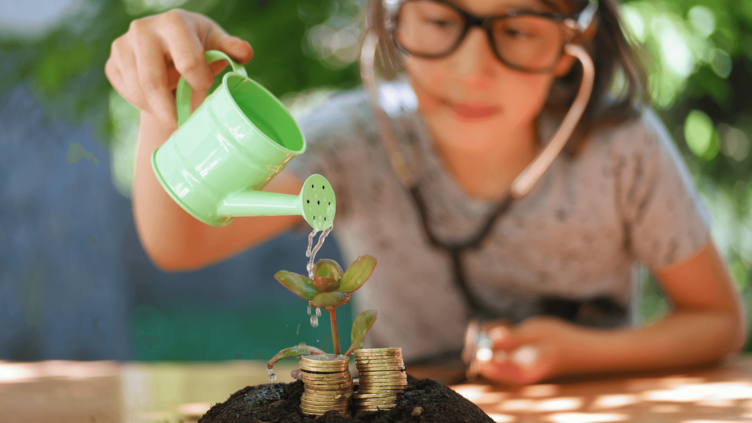 little girl with glasses watering a pile of coins