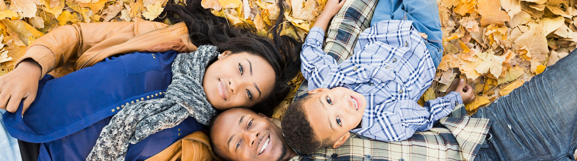 family laying in leaves